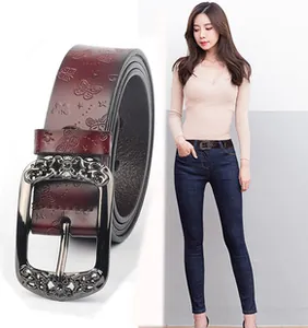 Detailed view of women's leather belt with butterfly embossing and silver carved buckle