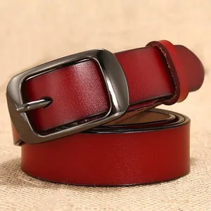 Close-up of vintage red leather belt texture and dark metal buckle on linen fabric