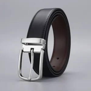 Detail of a men's reversible leather belt showing black and brown sides with silver buckle