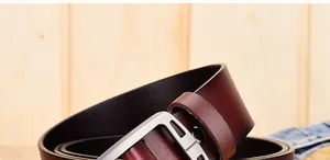 Dettaglio della cintura in pelle bordeaux con trama fine e fibbia in metallo argento