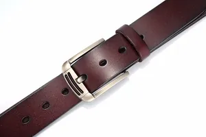 Gros plan d'une ceinture pour hommes en cuir marron foncé avec boucle en métal brossé