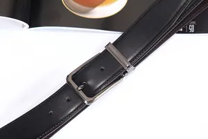 Dettaglio cintura in pelle nera con fibbia ad ardiglione grigio canna di fucile e cuciture