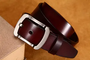 Dettaglio di una cintura in pelle marrone scuro con fibbia ad ardiglione in argento spazzolato