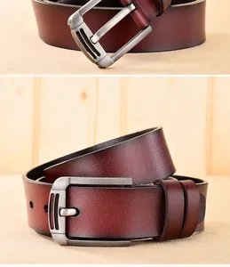 Gros plan sur la boucle en métal brossé et le grain du cuir de la ceinture bordeaux