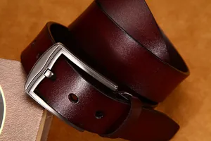 Dettaglio macro della cintura in pelle da uomo con fibbia in metallo e finitura vellutata