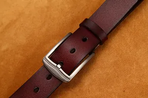 Dettaglio cintura in pelle bordeaux con fibbia in argento spazzolato e trama fine
