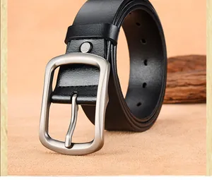 Macro detail of men's black leather belt with matte silver buckle and fine grain texture