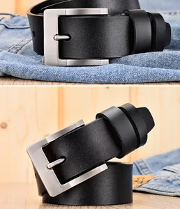 Detail van zwarte lederen riem met een zilveren geborstelde metalen gesp op denim