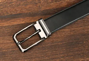 Detail of classic black leather belt showing stitching and silver metal buckle