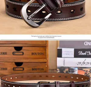 Macro detail of dark brown leather belt with silver needle buckle and white double stitching
