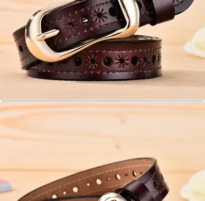 Detail van een donkerbruine leren riem met bloemmotief uitsnijdingen en gouden gespsluiting