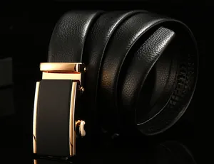 Close-up of black leather belt with lychee texture and gold automatic buckle on black surface