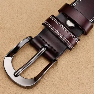 Macro shot of dark brown leather belt with contrast stitching and dark gray buckle