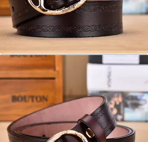 Detail of vintage dark brown embossed leather belt with engraved golden round buckle