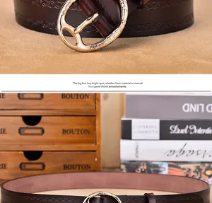 Detail of vintage dark brown leather belt featuring an ornate gold buckle and embossed texture