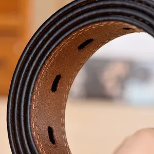Macro shot of black leather belt featuring dual-layer construction and beige stitching