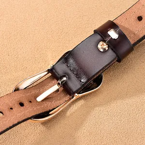 Detailopname van een donkerbruine leren riem met een gepolijste gouden metalen gesp