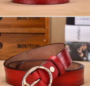 Detail of vintage dark red embossed leather belt with ornate golden round buckle