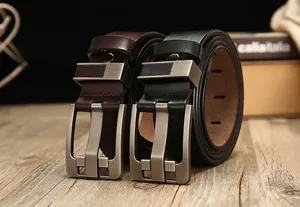 Detalle de cinturones de cuero vintage en marrón oscuro y negro con hebillas de metal mate