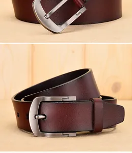 Detail of burgundy leather belt with brushed metal pin buckle on wooden background