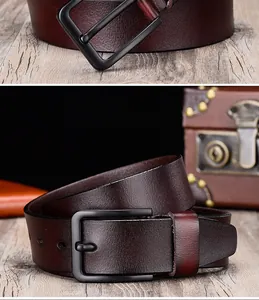 Close-up of premium burgundy leather belt with matte black buckle on vintage wood