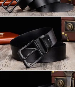 Close-up of a black leather belt with matte metal pin buckle on a vintage desk