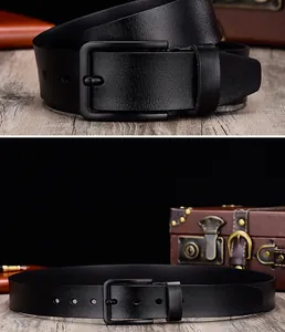 Detail of black leather belt with matte buckle on wooden background and leather case