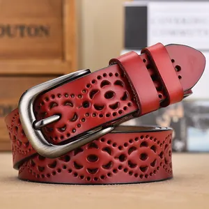Dames riem van rood leer met decoratieve bloemuitsparingen en zilveren metalen gesp