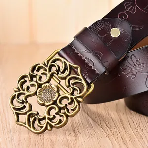 Gros plan sur ceinture en cuir vintage avec gaufrage floral et boucle fleurie en bronze