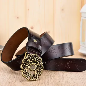 Gros plan sur ceinture en cuir vintage avec gaufrage floral et boucle en métal ajouré