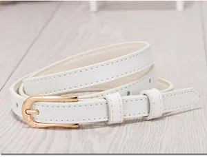 Detail of white skinny belt featuring a golden horseshoe buckle with heart engraving