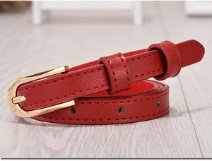 Detailed close-up of a slim red leather belt featuring a gold buckle with heart engraving