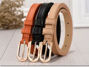 Detail view of thin women belts with golden U-shaped buckles and heart cut-out patterns