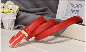 Detail of red leather belt with gold rhinestone automatic buckle and lychee texture