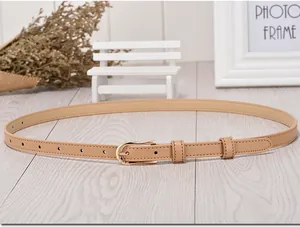 Detail of thin camel leather belt for women with elegant golden oval buckle and stitching