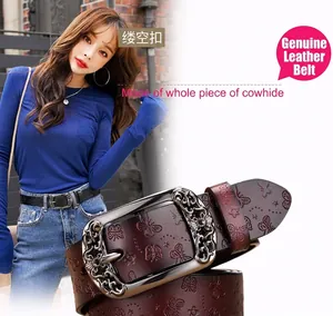 Détail des motifs papillon gaufrés sur la ceinture vintage en cuir marron rouge