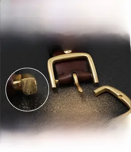 Detailed view of solid copper pin buckle and premium brown leather belt texture