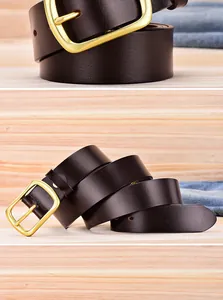 Detail of dark brown leather belt with gold buckle on wooden and denim background
