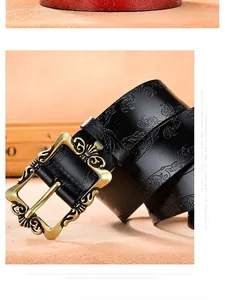 Detail of vintage embossed leather belt with floral patterns and bronze buckle