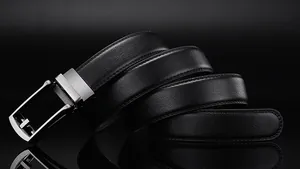 Detailed macro view of black lychee grain leather belt with silver automatic metal buckle