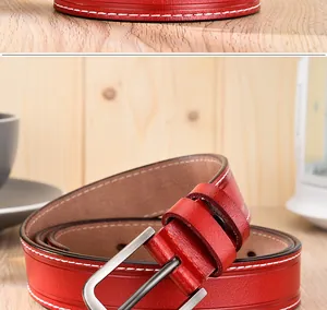 Vue détaillée d'une ceinture en cuir rouge foncé avec surpiqûres blanches et boucle argent