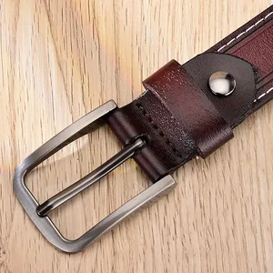 Gros plan sur une ceinture en cuir vintage avec boucle argentée et coutures blanches