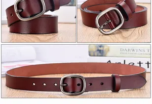 Macro detail of dark reddish brown leather belt with vintage oval metal buckle and texture