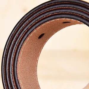 Macro d'un bord de ceinture en cuir noir avec couture blanche et doublure brune