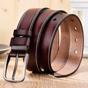 Gros plan sur une ceinture en cuir bordeaux avec surpiqûres et boucle en métal brossé