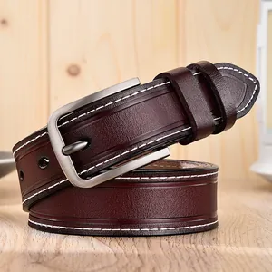 Ceinture en cuir bordeaux avec coutures blanches et boucle argentée sur fond en bois