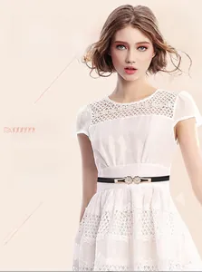 Detail of a thin black leather belt featuring a gold floral rhinestone buckle on a dress