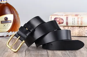 Detail of premium black leather belt with matte gold pin buckle on wooden table