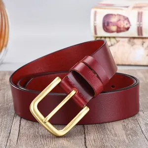 Macro shot of men's genuine cowhide leather belt showing fine grain and vintage brass buckle