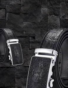 Close-up of black crocodile leather belt with silver automatic buckle and embossed logo